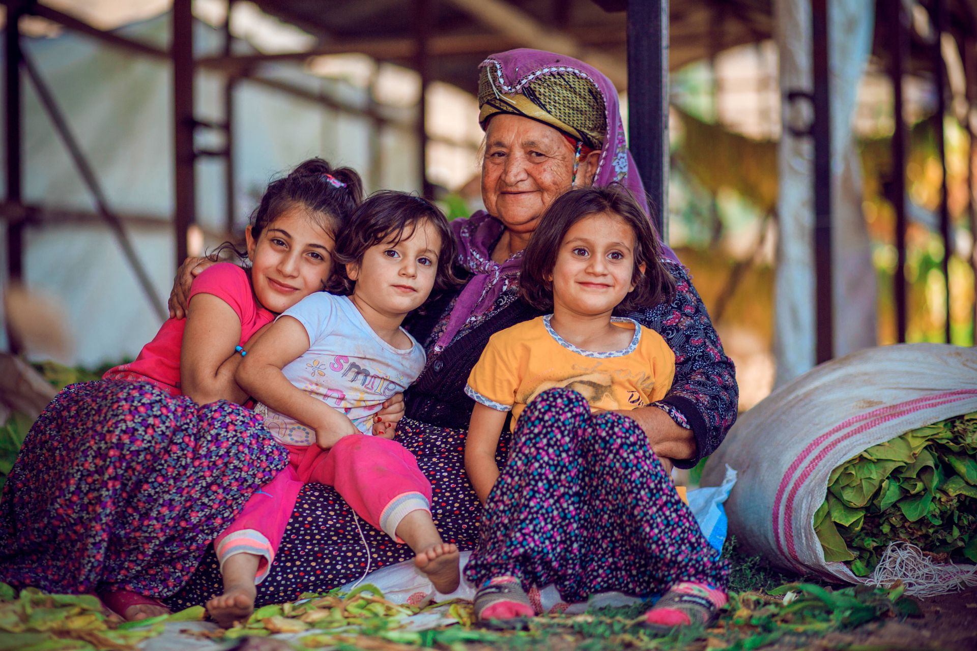 A grandmother smiling with her grandchildren indoors.